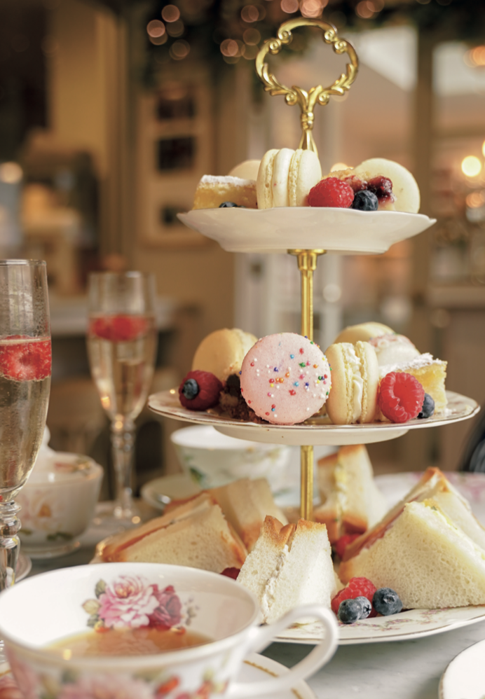 Torre de afternoon tea con macarons, sándwiches y copas de champán